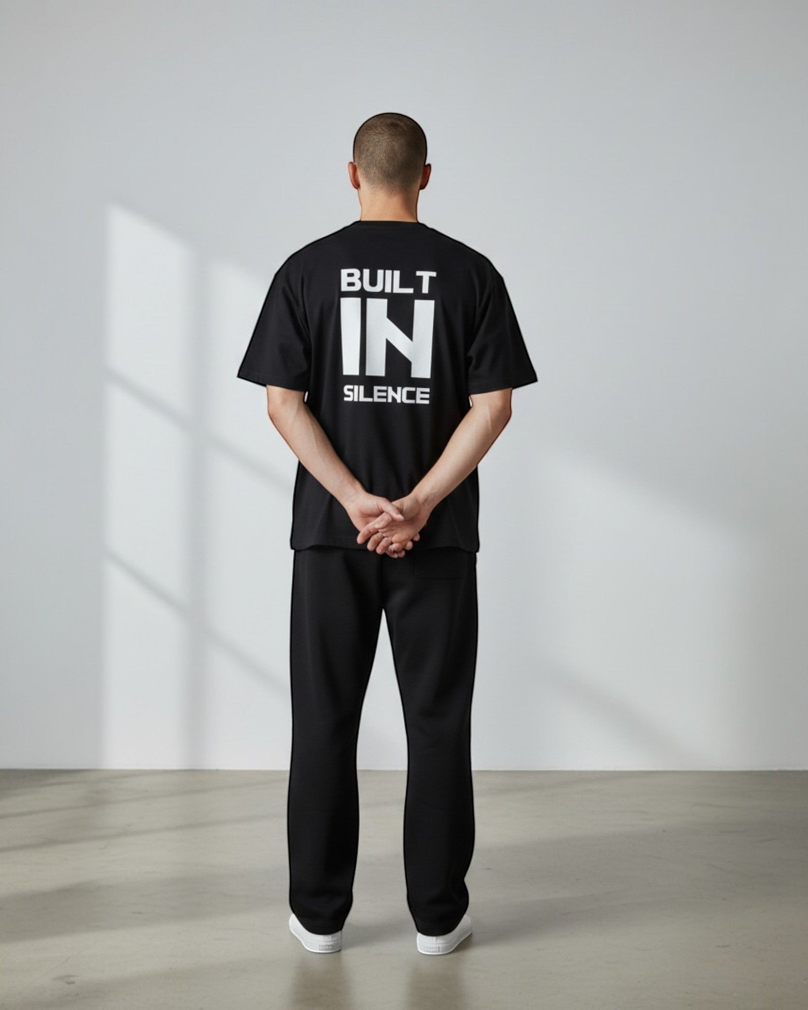 FALLR wear black 100% cotton oversized t-shirt with white "BUILT IN SILENCE" graphic print on back.