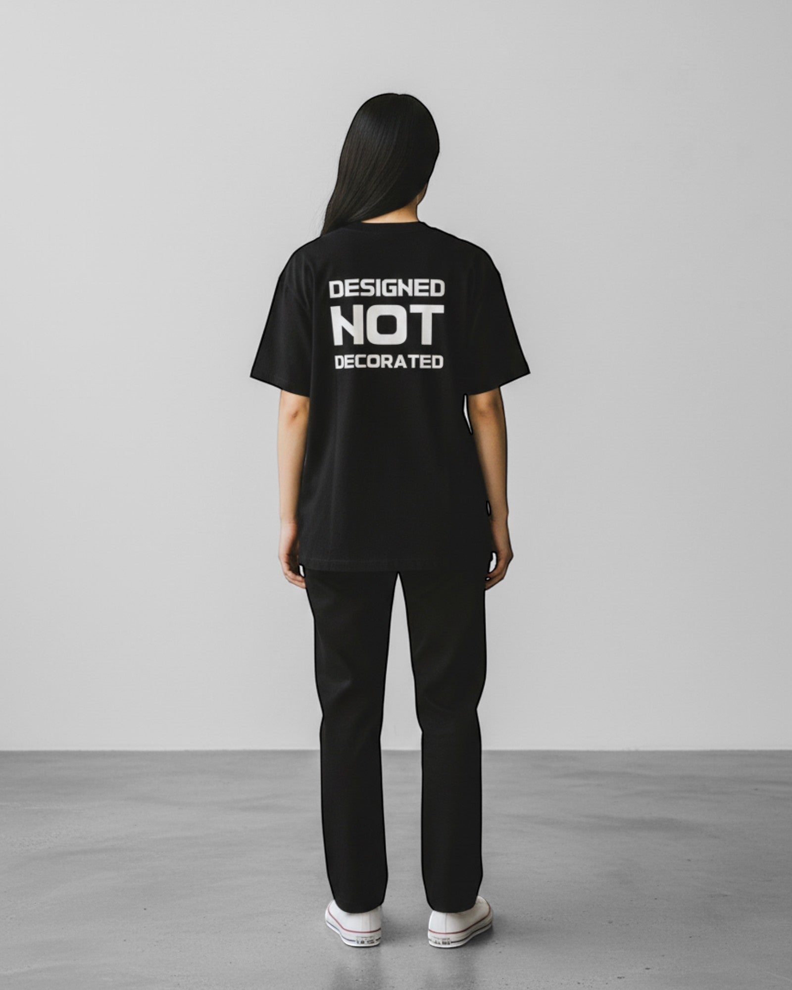 FALLR wear black 100% cotton unisex oversized t-shirt with white 'DESIGNED NOT DECORATED' graphic print on back.