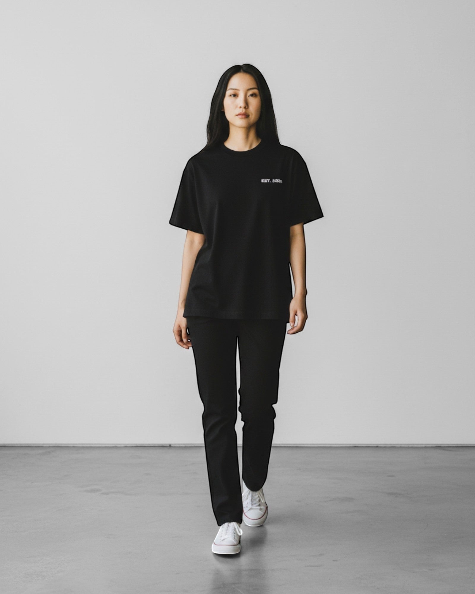 FALLR wear black 100% cotton oversized t-shirt with minimalist graphic print on chest, worn by a woman.