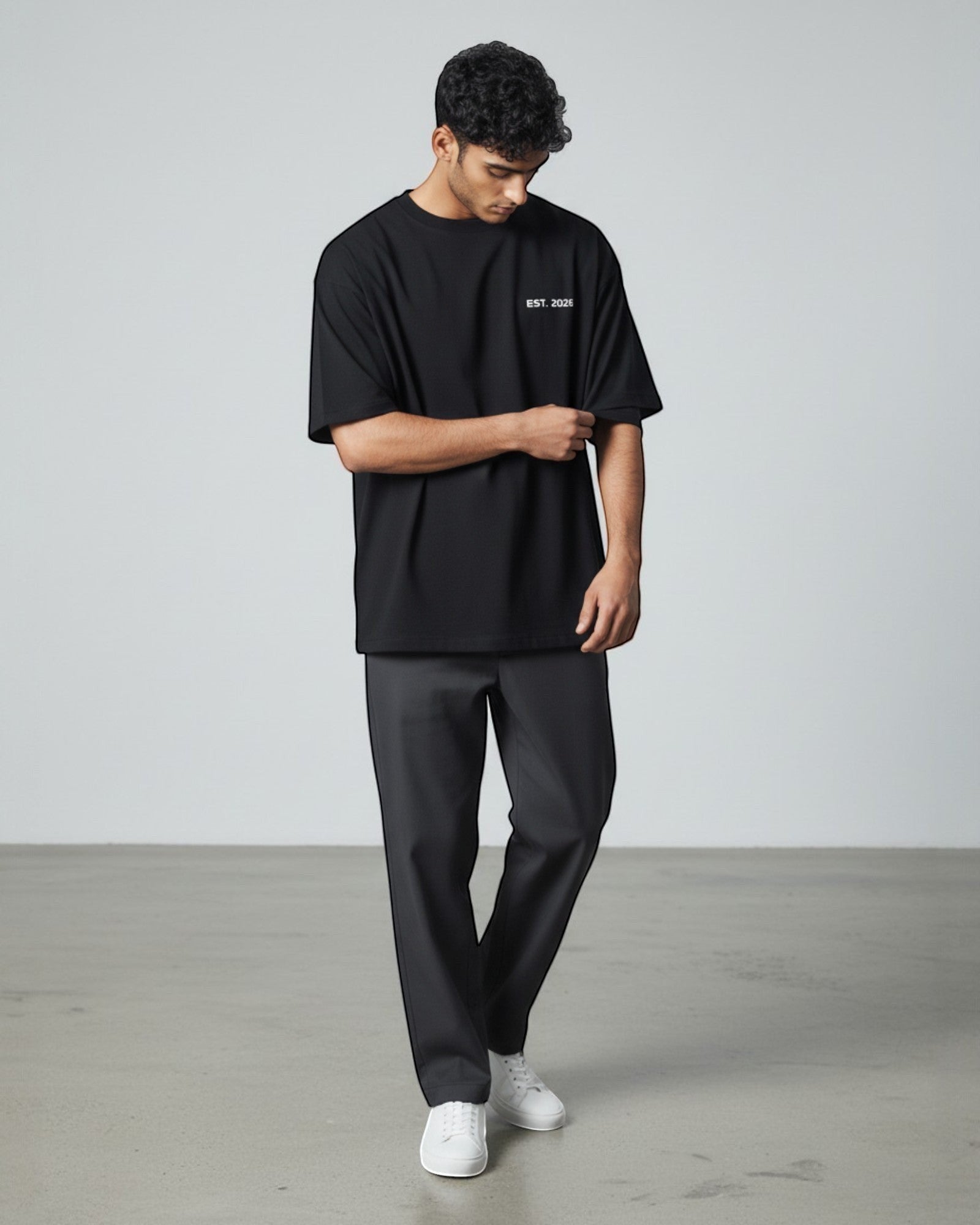 FALLR wear black 100% cotton oversized t-shirt with minimalist 'EST. 2026' graphic, worn by a man with dark hair.