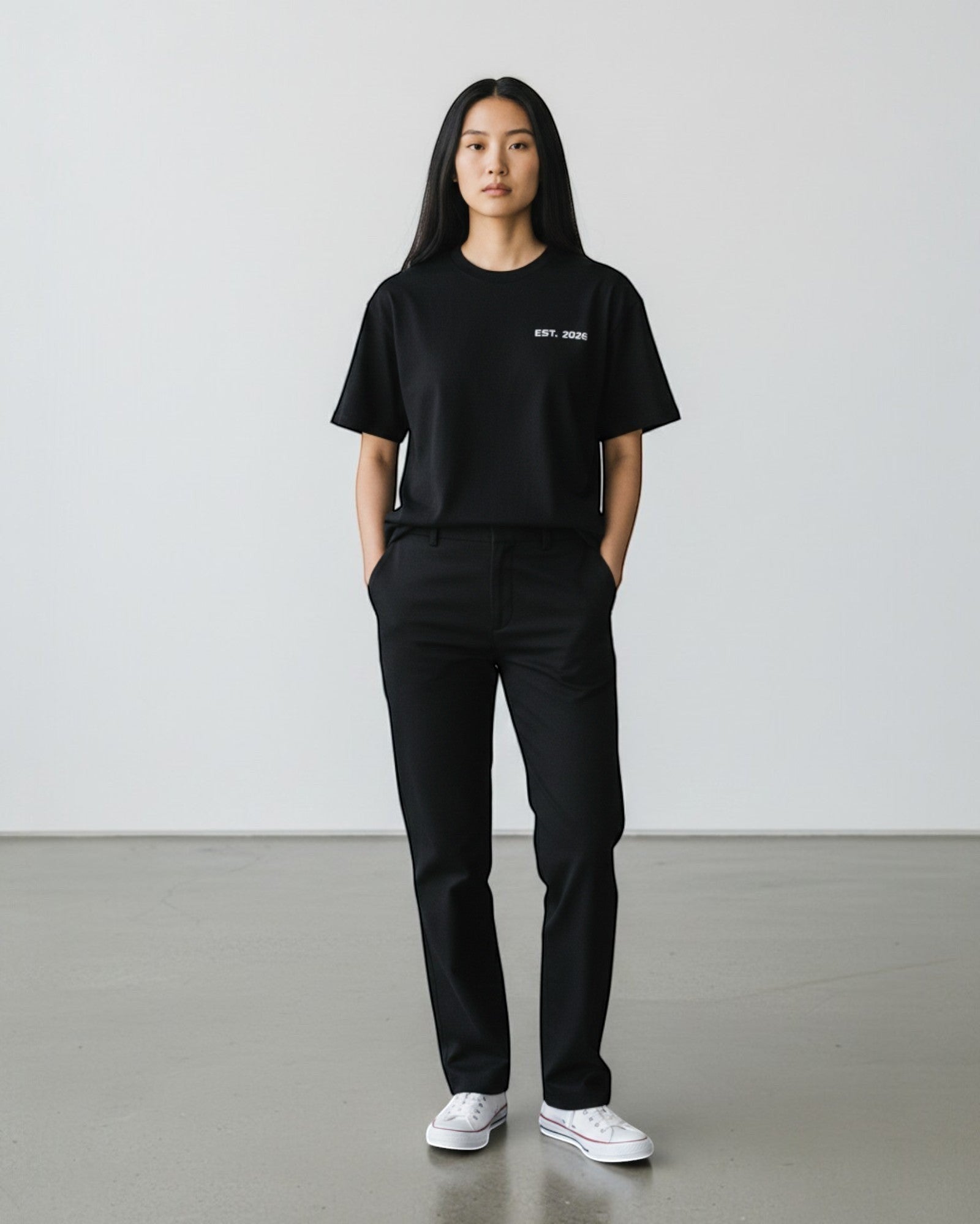FALLR wear black 100% cotton oversized t-shirt with minimalist white text graphic on chest, worn by a woman.