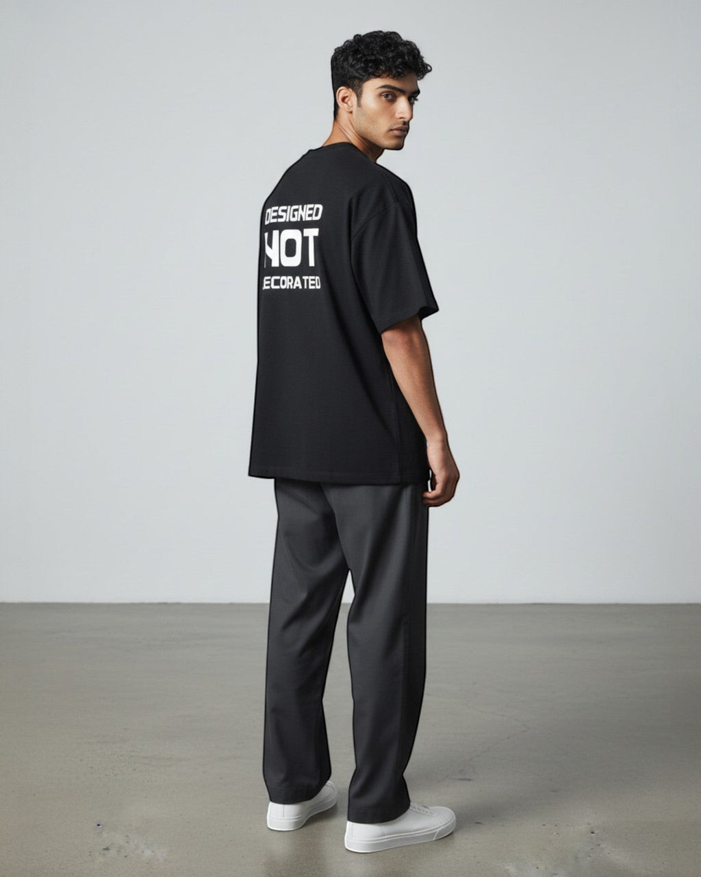 FALLR wear black 100% cotton oversized unisex t-shirt with white "DESIGNED NOT DECORATED" graphic print on back.