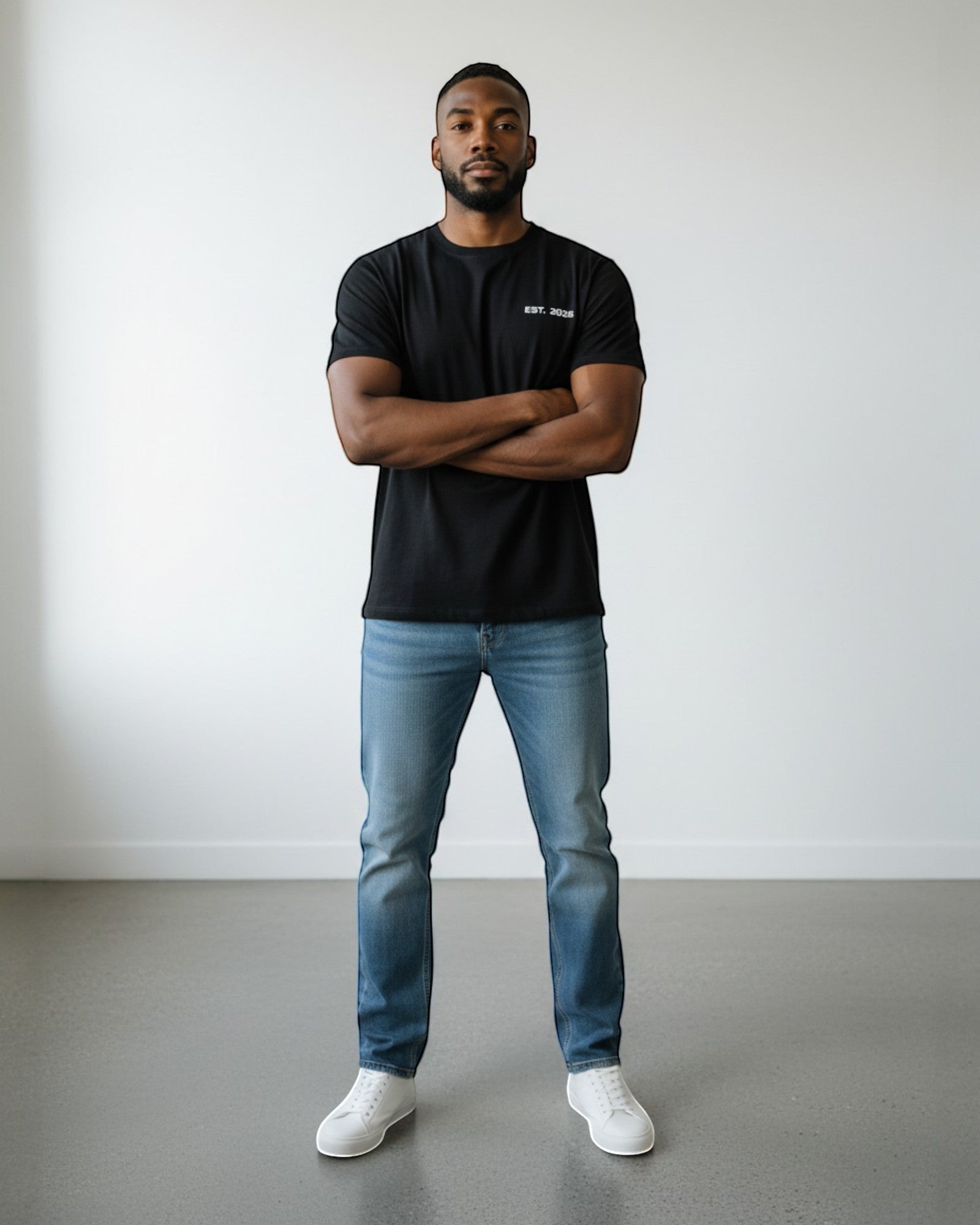 FALLR wear black 100% cotton t-shirt with minimalist "EST. 2025" graphic print, worn by a man with arms crossed.