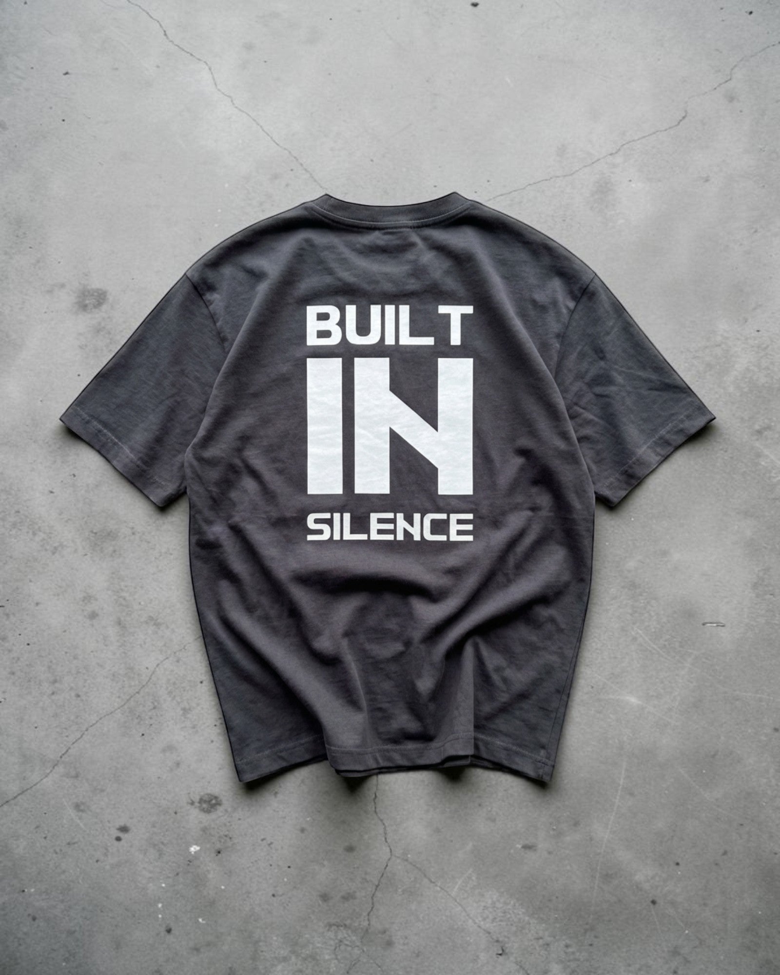 FALLR wear dark grey 100% cotton oversized graphic t-shirt with white "BUILT IN SILENCE" print on back.