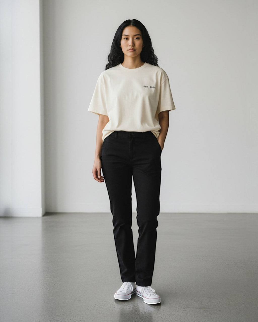 FALLR wear cream 100% cotton oversized t-shirt with black 'EST. 2025' graphic, paired with black trousers and white sneakers.