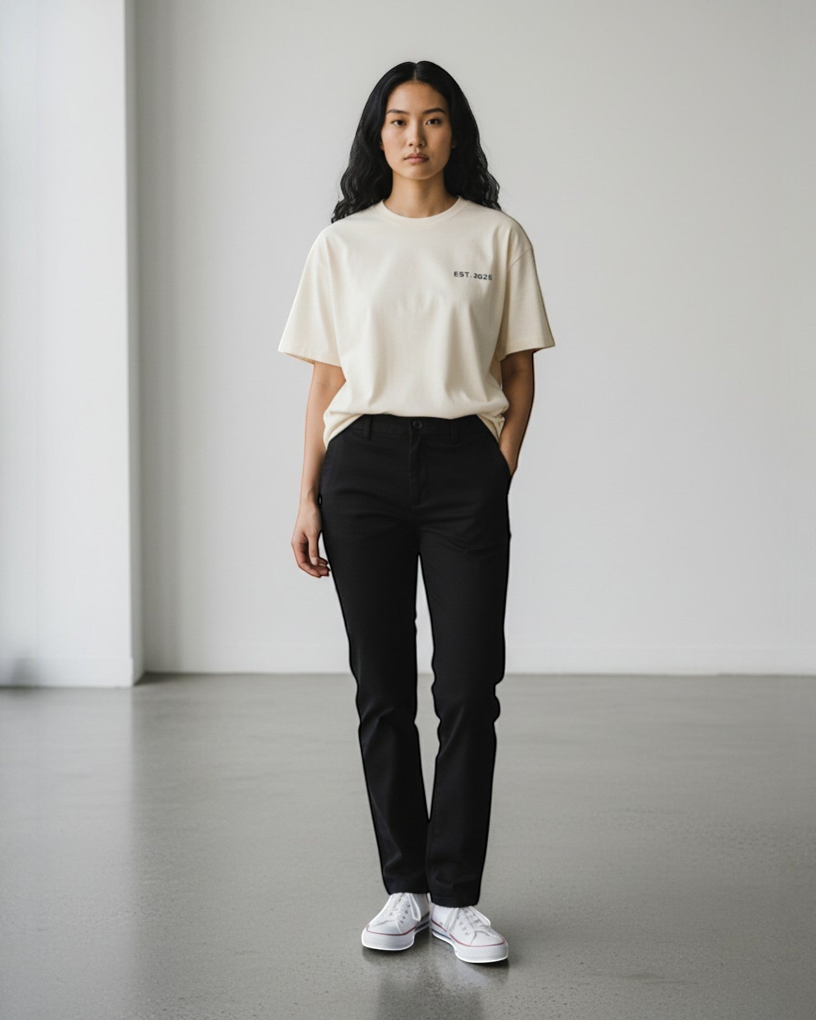 FALLR wear cream 100% cotton oversized t-shirt with black 'EST. 2025' graphic, paired with black trousers and white sneakers.