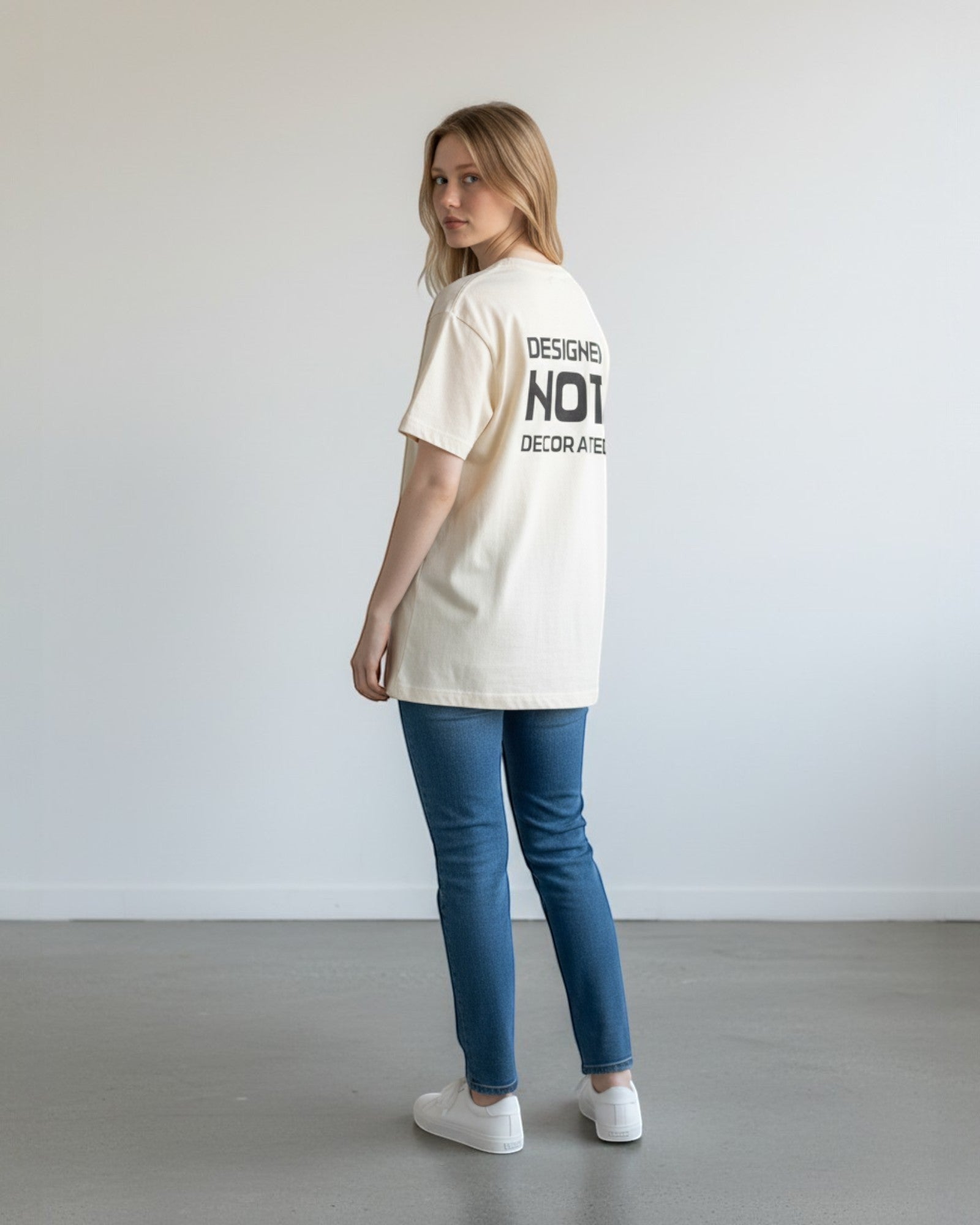 FALLR wear cream 100% cotton oversized unisex t-shirt with black 'Designed Not Decorated' graphic on back.