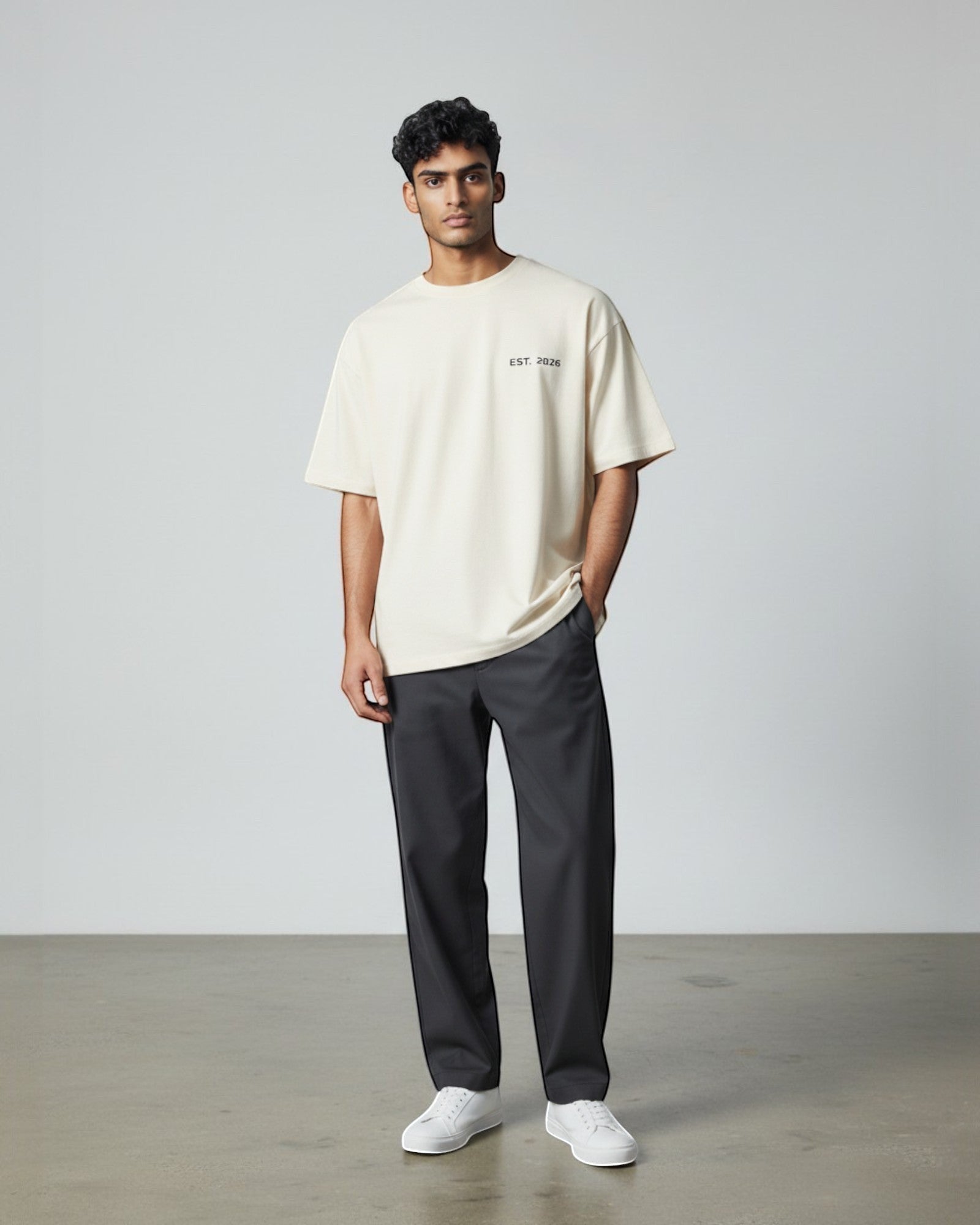 FALLR wear men's cream 100% cotton oversized t-shirt with 'EST. 2026' graphic, paired with dark grey trousers.