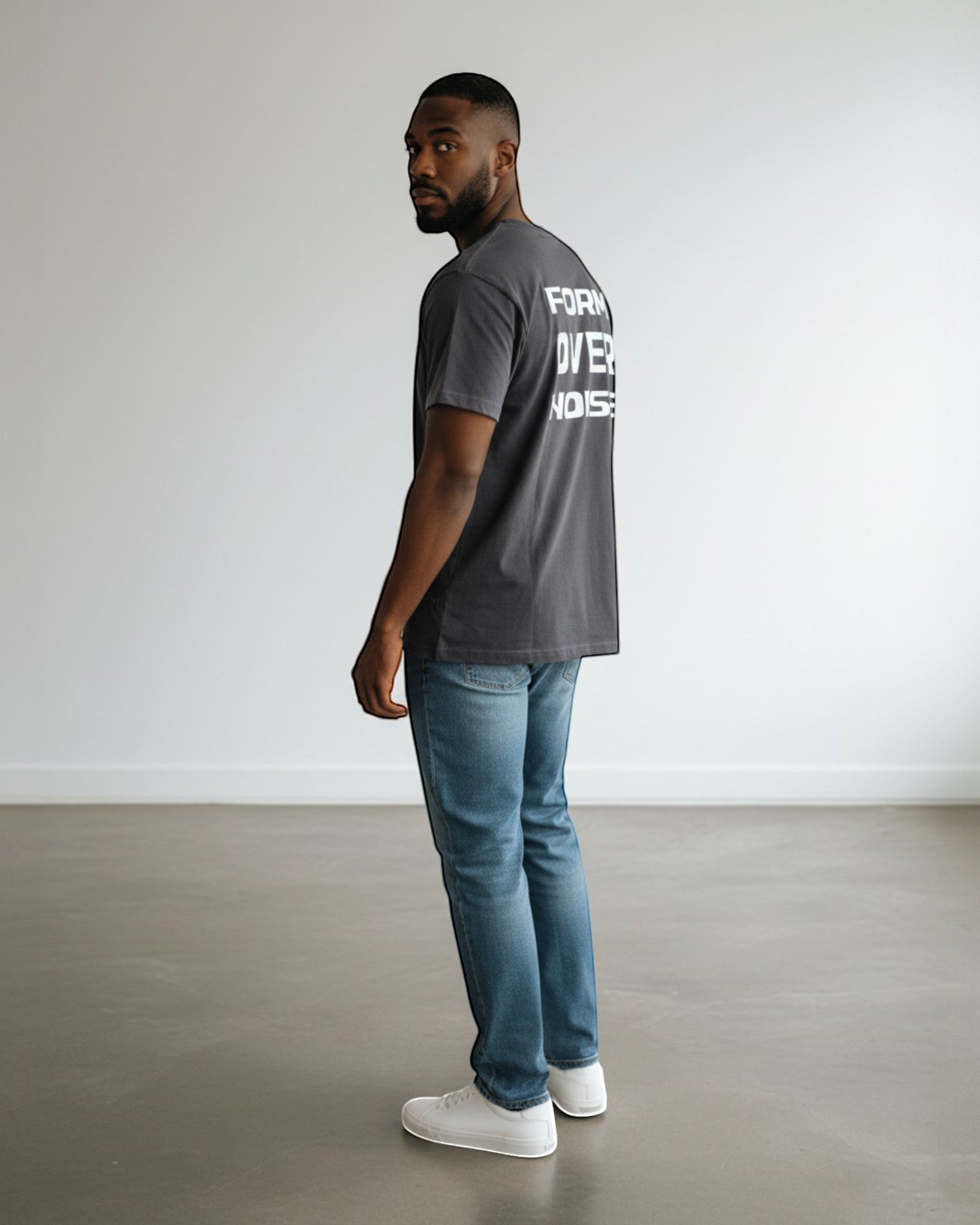 FALLR wear dark grey 100% cotton oversized graphic print t-shirt worn by a man with blue jeans and white sneakers.