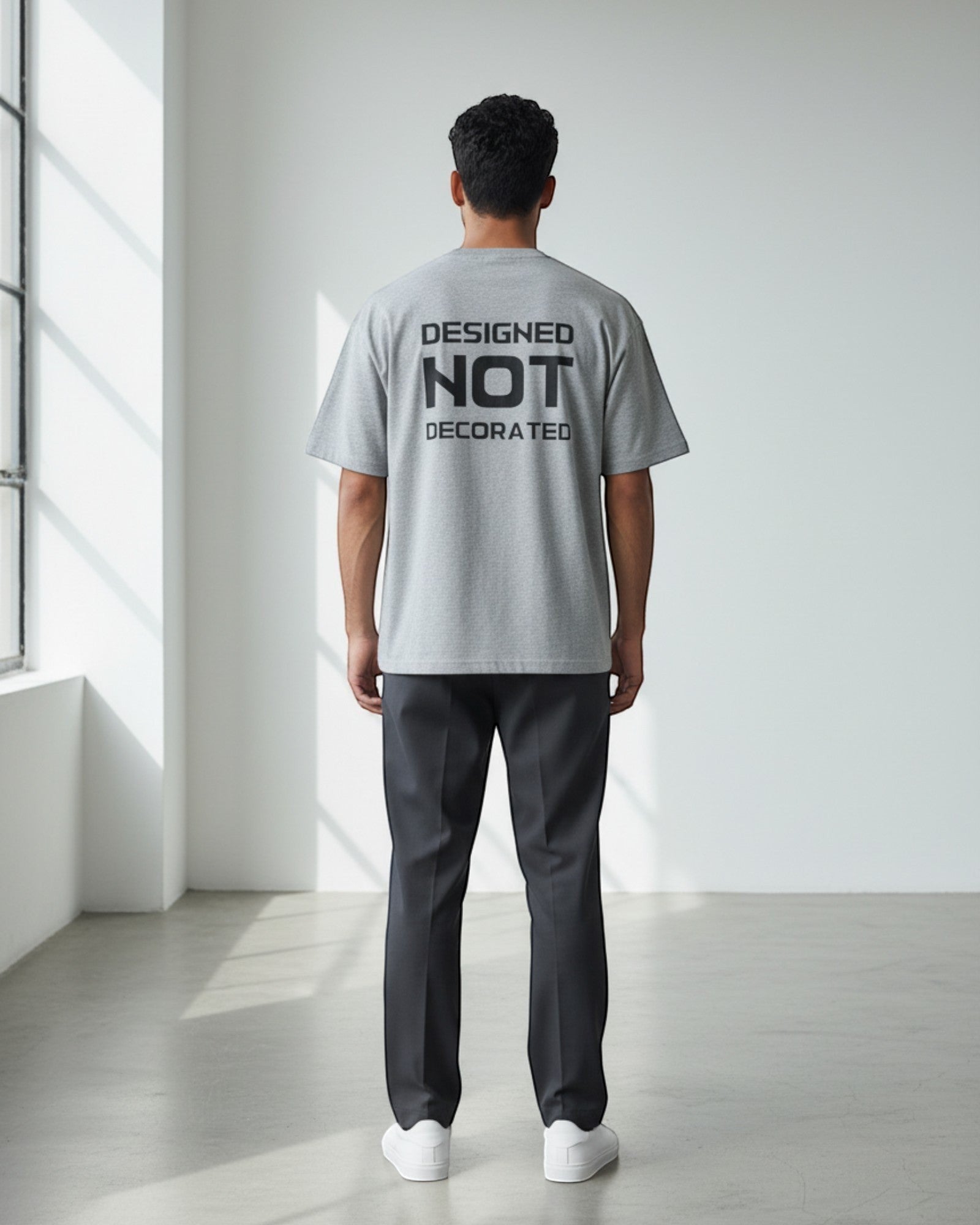 FALLR wear grey 100% cotton oversized unisex t-shirt with black 'DESIGNED NOT DECORATED' graphic print on back.