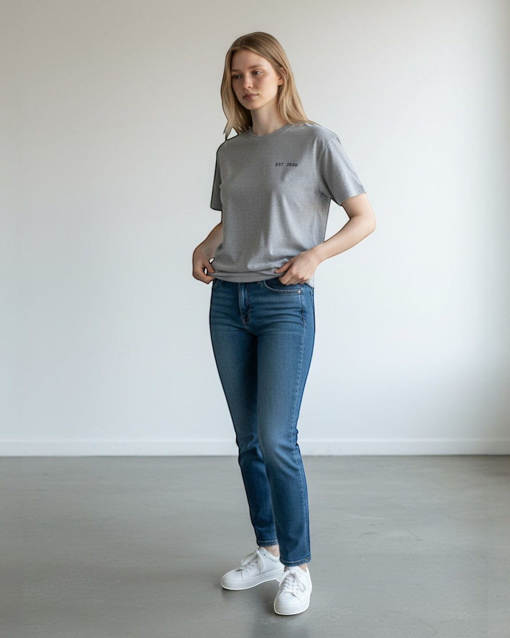 FALLR wear grey 100% cotton t-shirt with minimal black 'EST. 2020' graphic print on chest, worn by a woman with blue jeans.