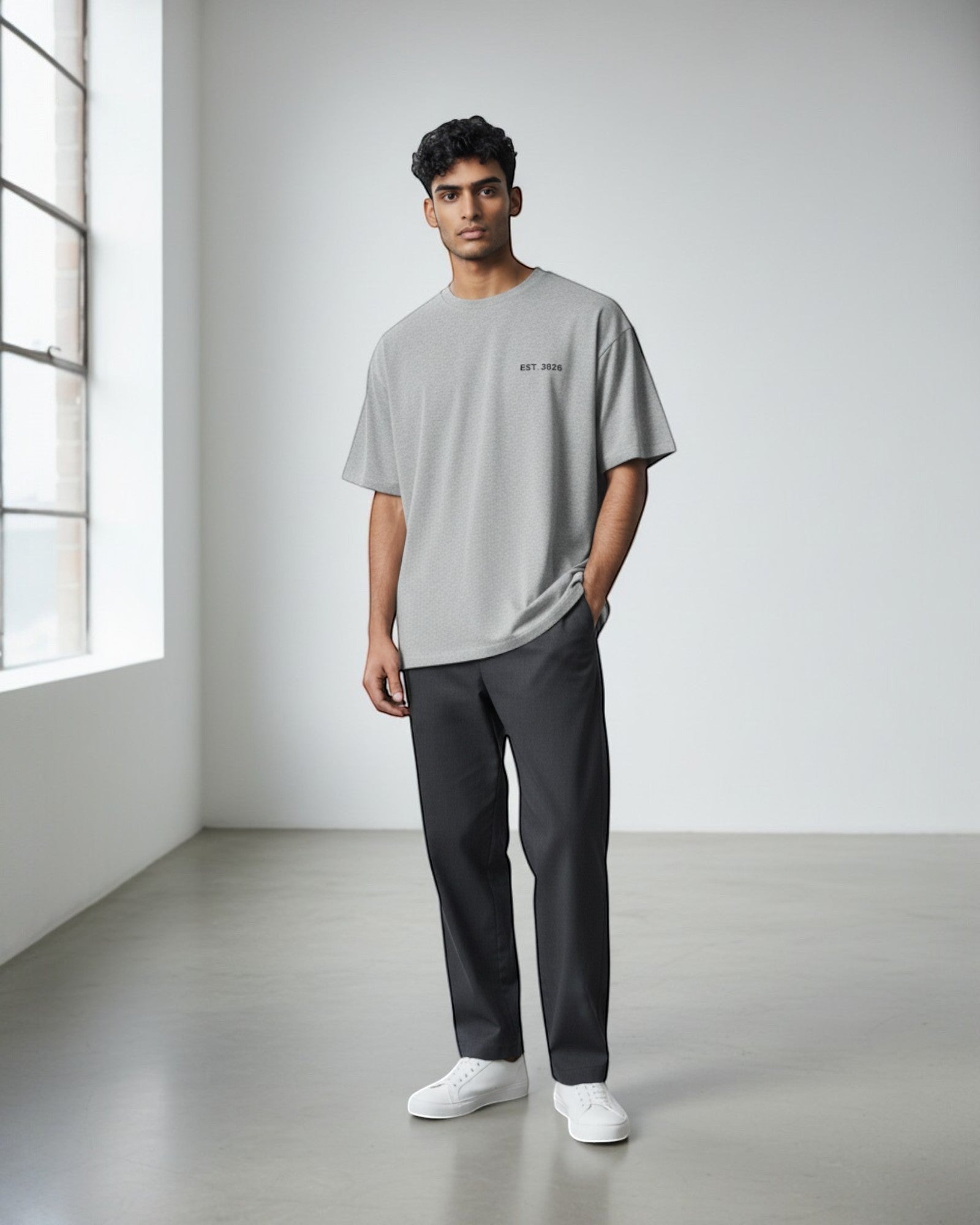 FALLR wear grey 100% cotton oversized t-shirt with subtle graphic print and relaxed fit, worn by a man with dark hair.