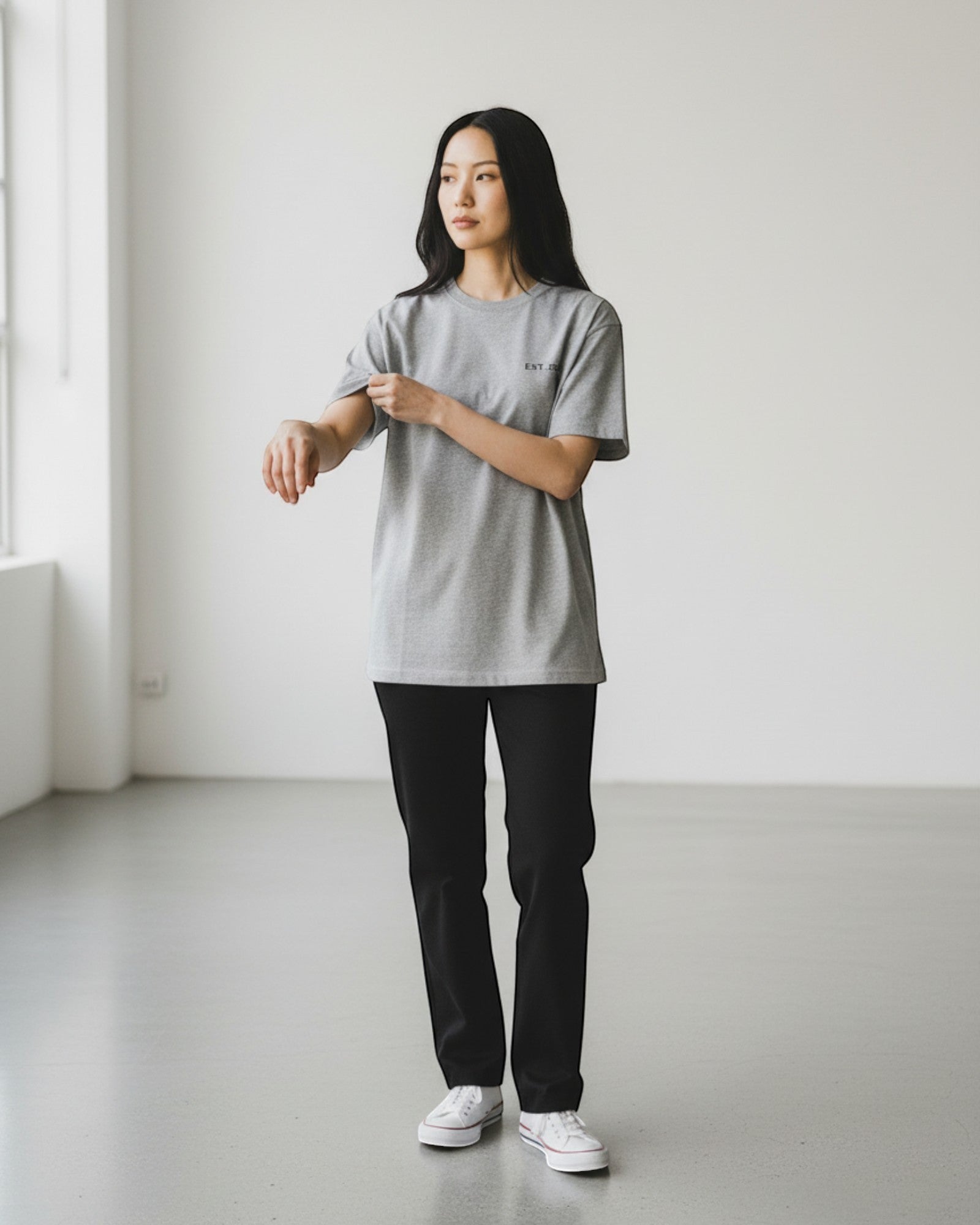 FALLR wear grey 100% cotton unisex oversized t-shirt with subtle chest logo, paired with black trousers and white sneakers.