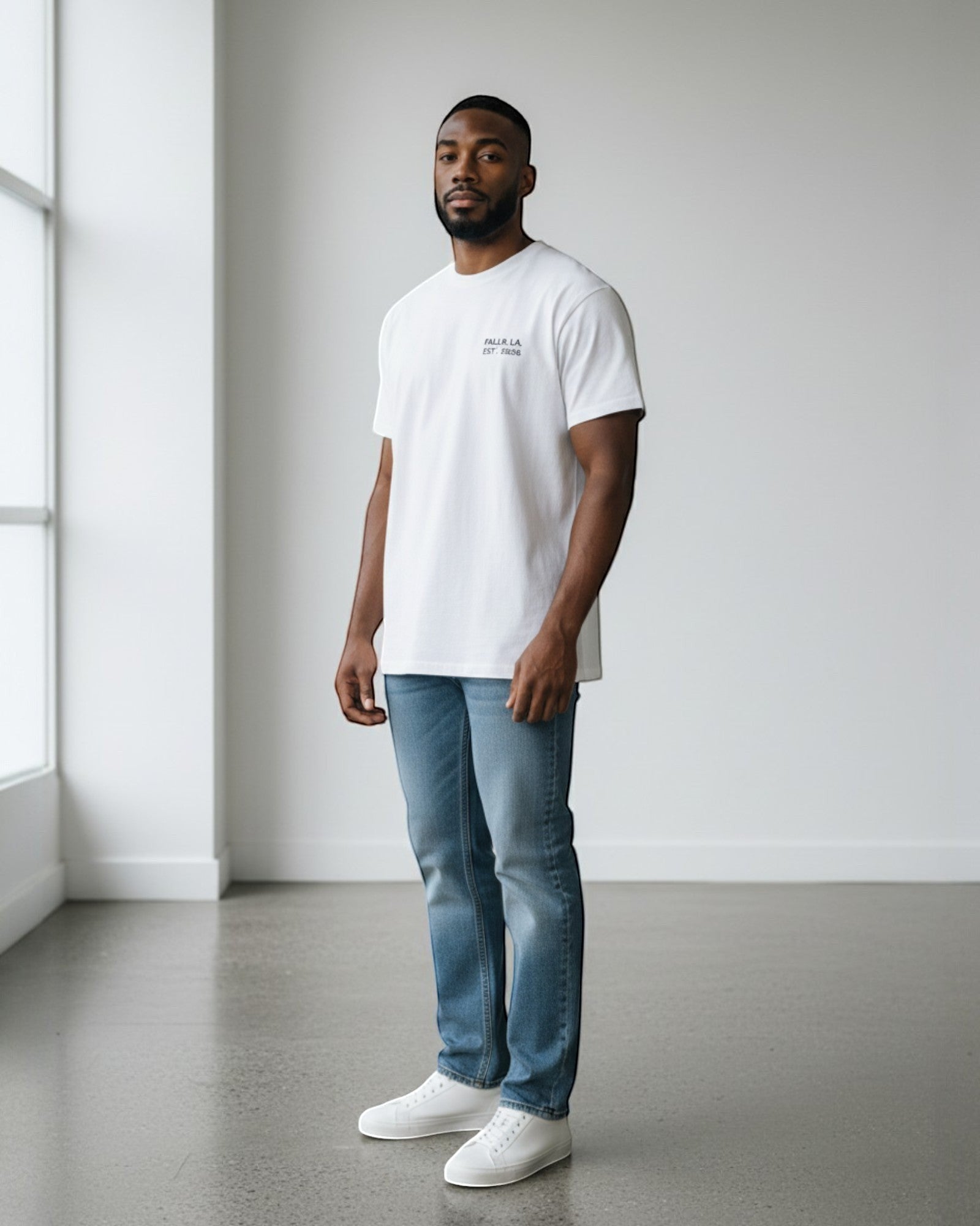 FALLR wear white 100% cotton oversized t-shirt with minimal graphic print, worn by a man with blue jeans and white sneakers.