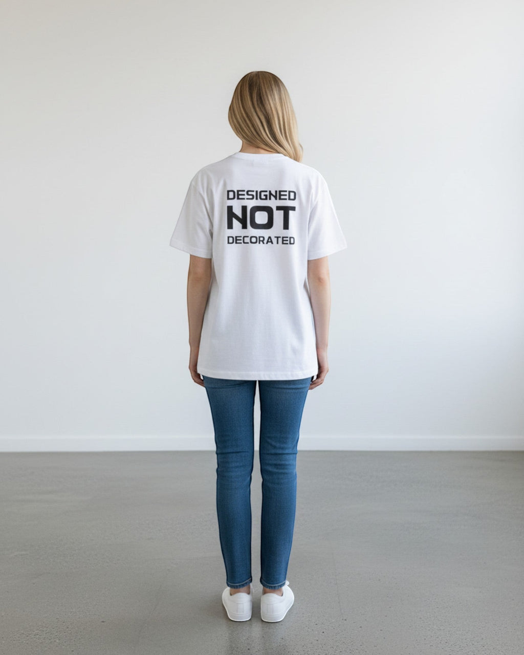 FALLR wear white 100% cotton unisex oversized t-shirt with black 'DESIGNED NOT DECORATED' graphic print on back.
