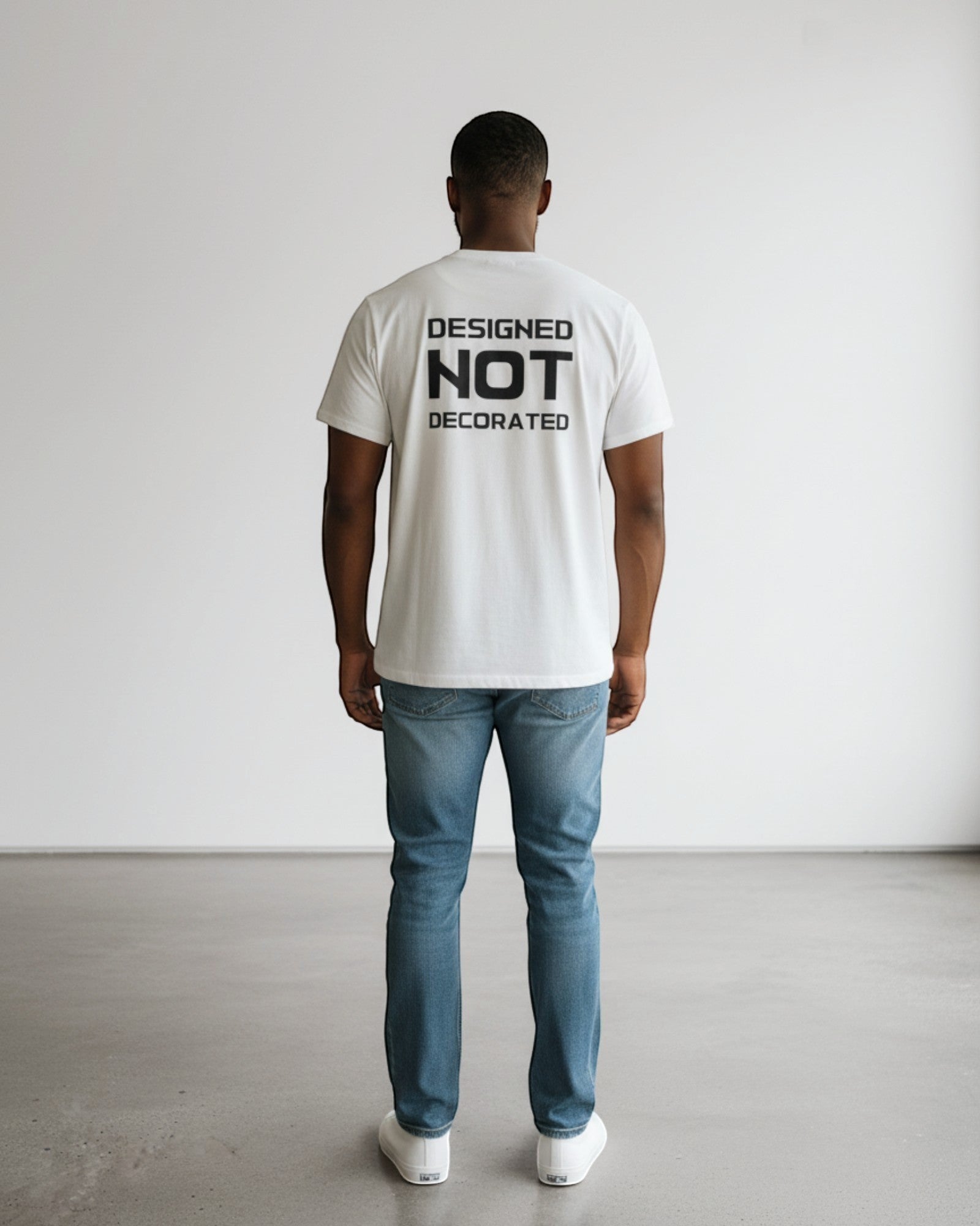 FALLR wear white 100% cotton unisex oversized t-shirt with black 'DESIGNED NOT DECORATED' graphic print on back.