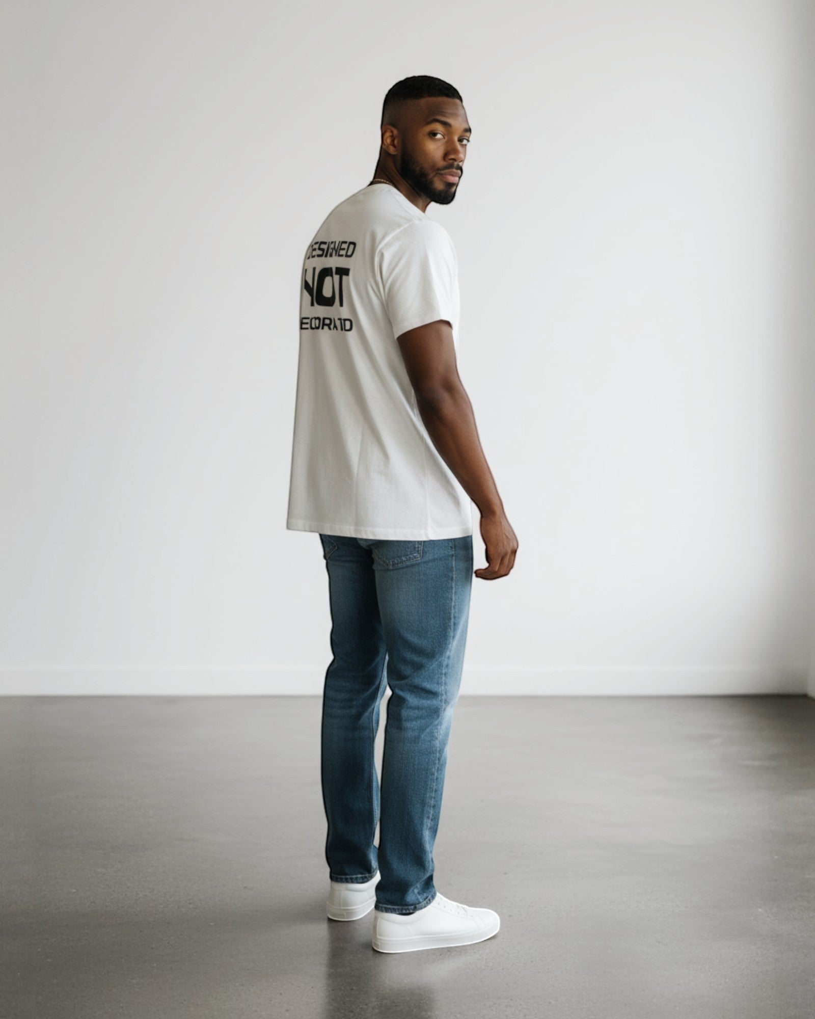 FALLR wear white 100% cotton unisex oversized tee with black graphic print on back, paired with blue denim jeans.